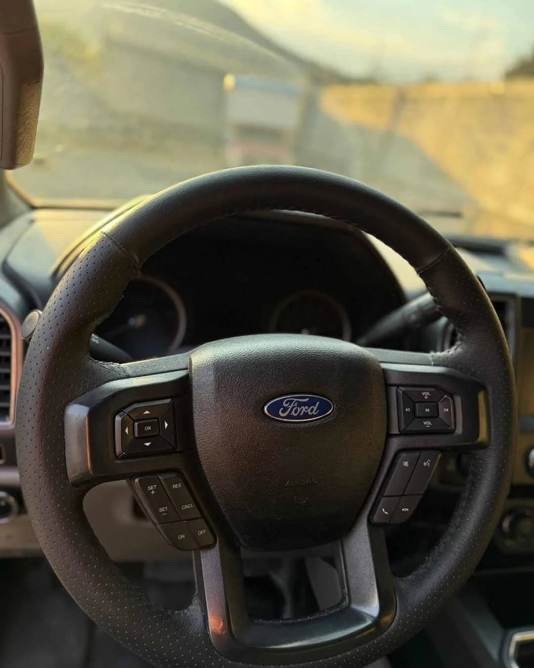 Volante de coche de la marca Ford, vista del interior en el tablero y la carretera a través del parabrisas.