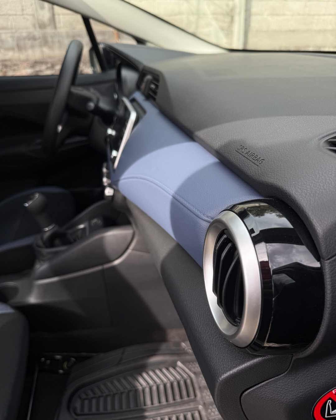 Interior de un coche, vista del tablero, aire acondicionado y parte del volante.