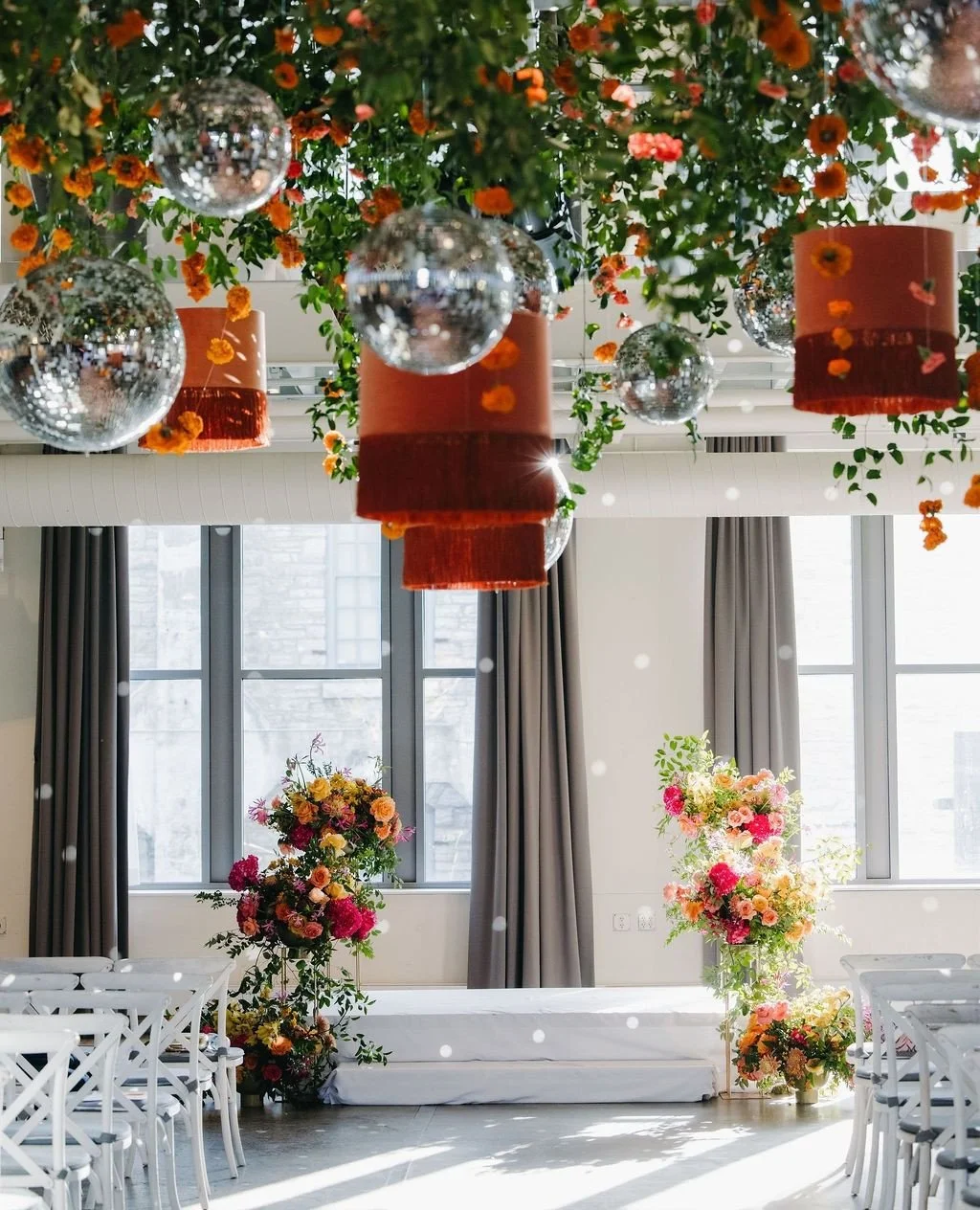 Disco balls, bold blooms, and sunlight pouring in made this ceremony setup feel like a party before the reception even started.⁠
⁠
Planning | ⁠@stylearchitectsweddings⁠
Venue | @machineshopmpls⁠
Catering | @indiapalacemn⁠
Staffing | @hostatoast⁠
Phot