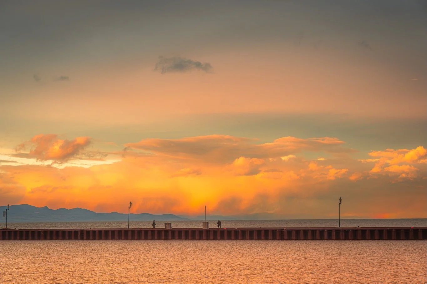 The November sky was awash in colour.&hellip;I saw these two people across the harbour, walking on the pier at sunset and wondered if they knew one other or were they strangers.

#documentary #art #photographer