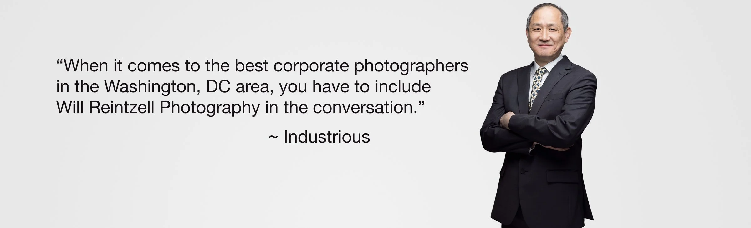 Corporate photographer endorsement with a person in a suit smiling and a quote about Will Reintzell Photography.