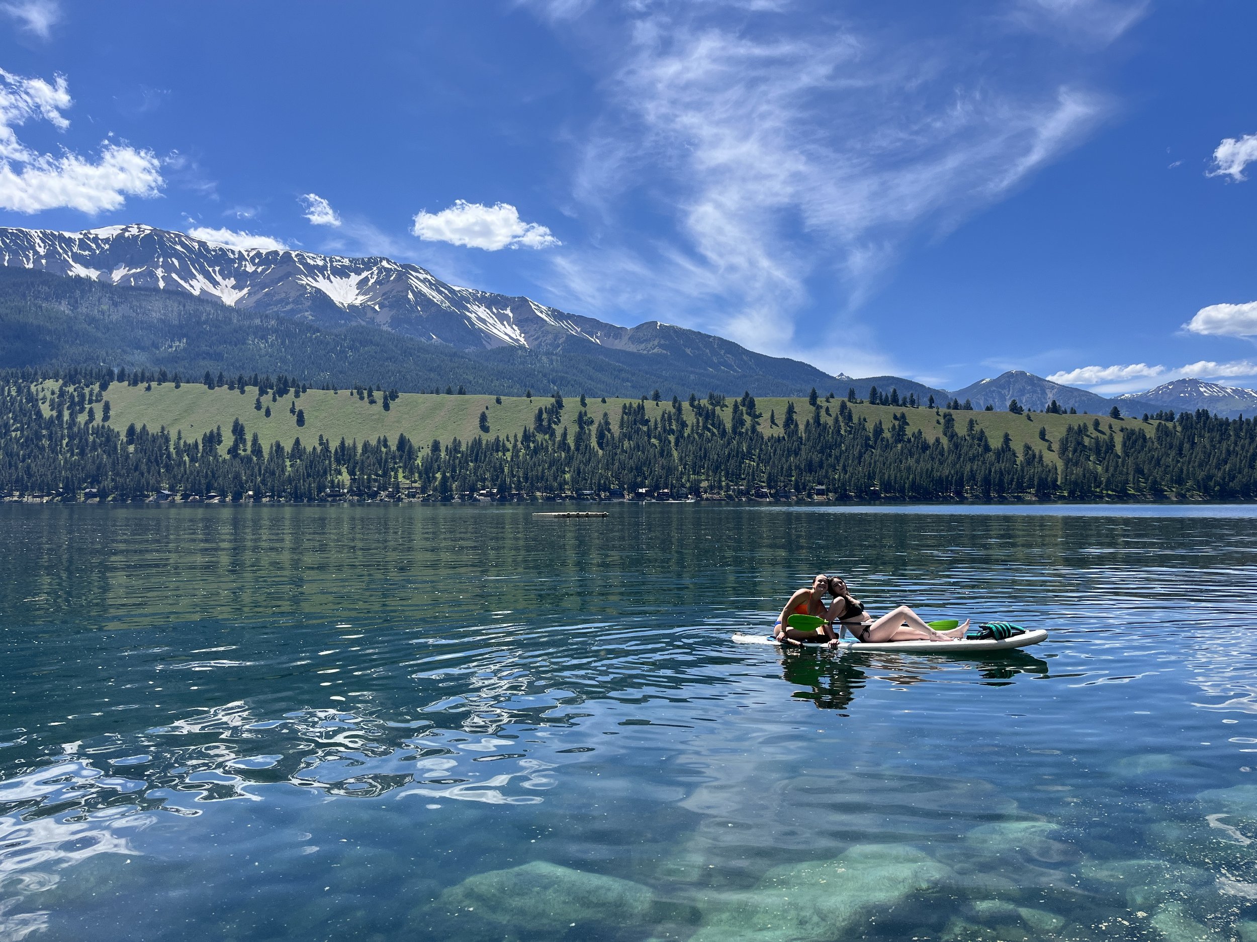 Peaceful mountain lake surrounded by evergreen trees, representing reflection and connection within the Divine Earth Church community.