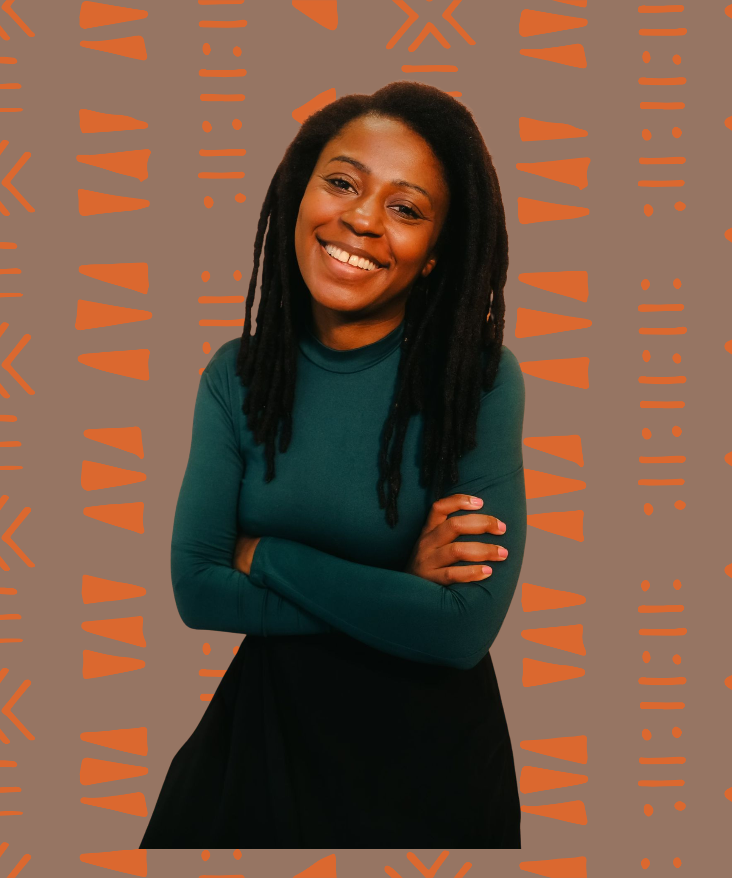 dark skinned Black femme with locs wearing a forest green turtleneck, smiling with their arms crossed.