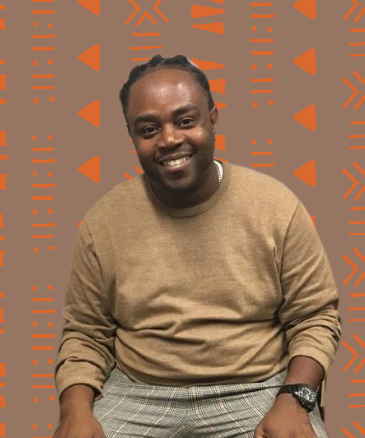 dark skinned Black man with locs, wearing a beige sweater and smiling.