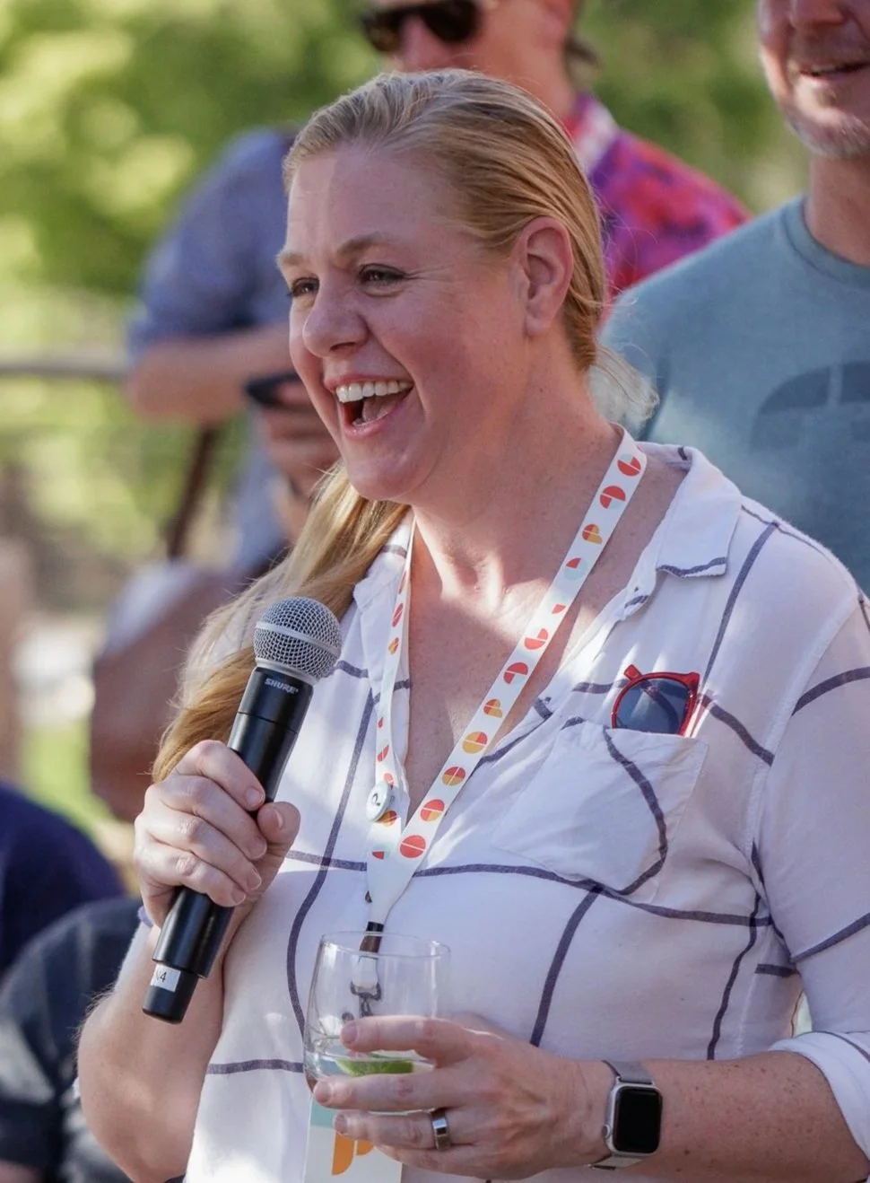 Ali Greco laughing while talking to group of people.