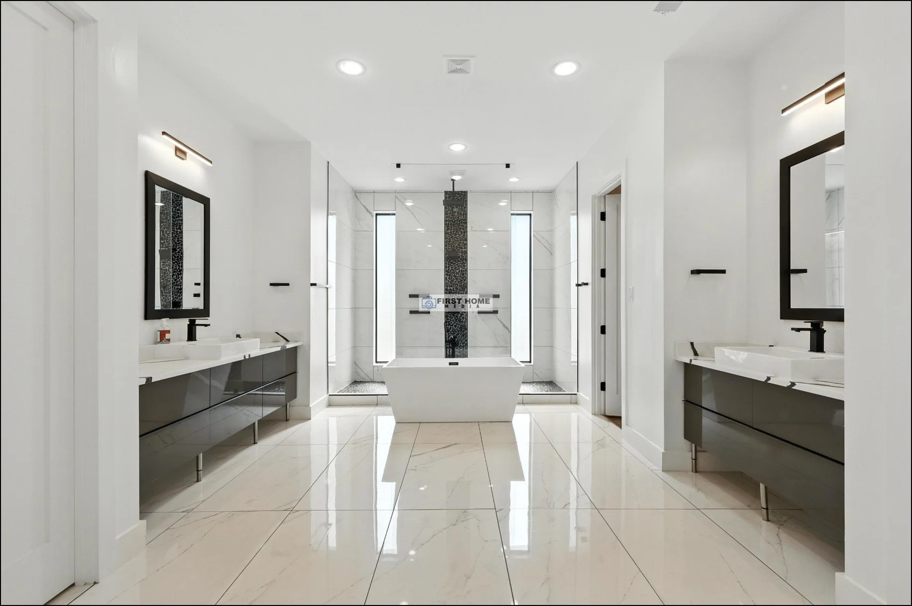 Modern luxury bathroom with white walls and marble floors, featuring two black-framed mirrors above black and white sinks, a bathtub centered between two tall, thin windows, and a large walk-in shower with marble walls behind the tub.
