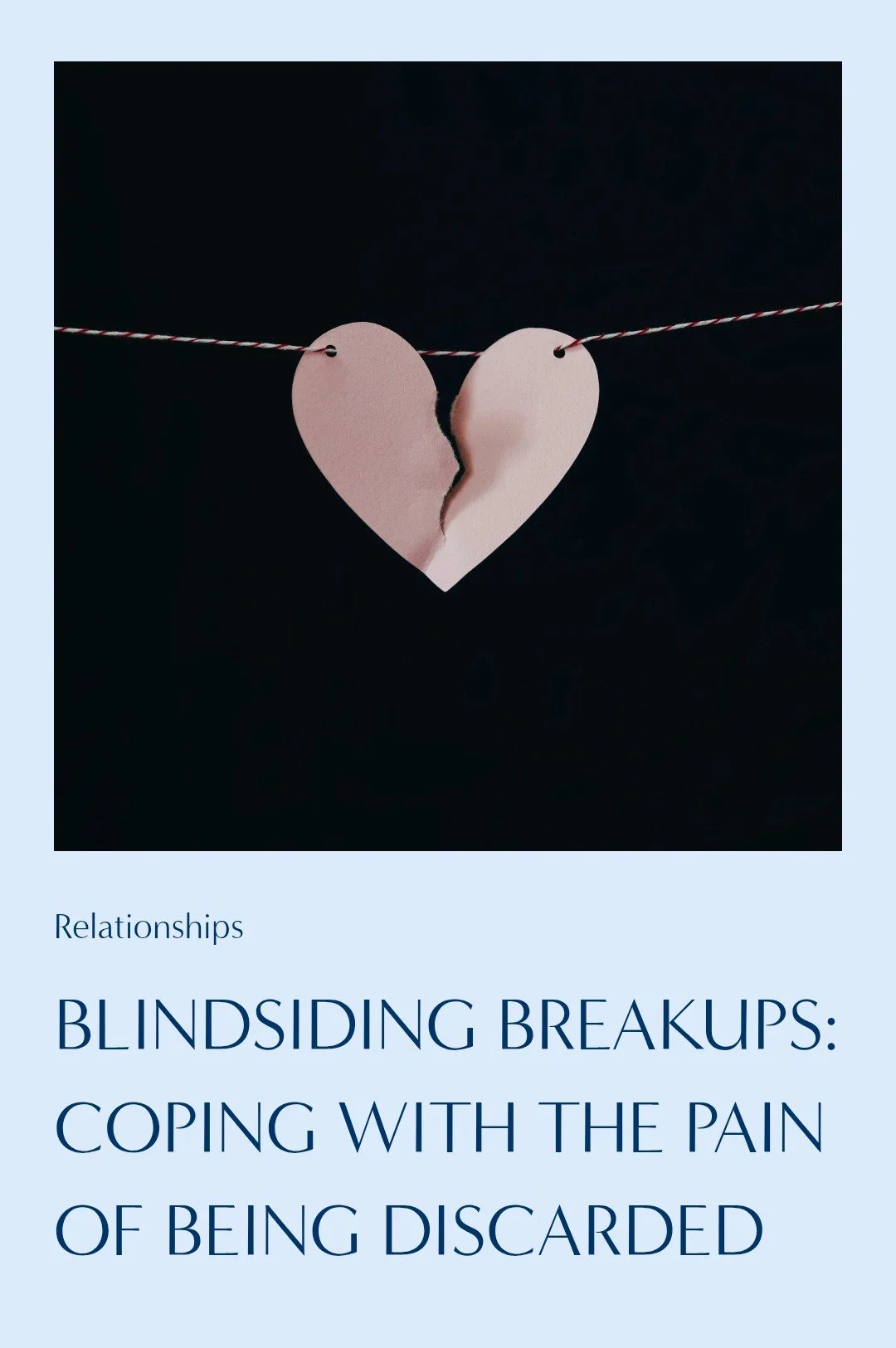 A torn pink paper heart hanging on a string against a dark background, with the top part of the heart on the left side and the bottom part on the right side.