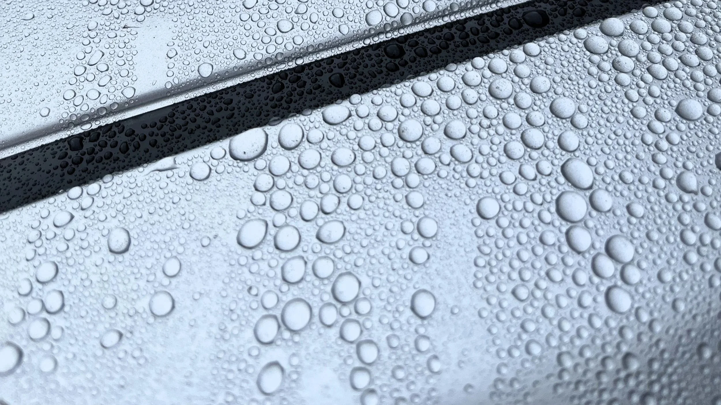 Ceramic coated car with water beading on the hood and glossy finish