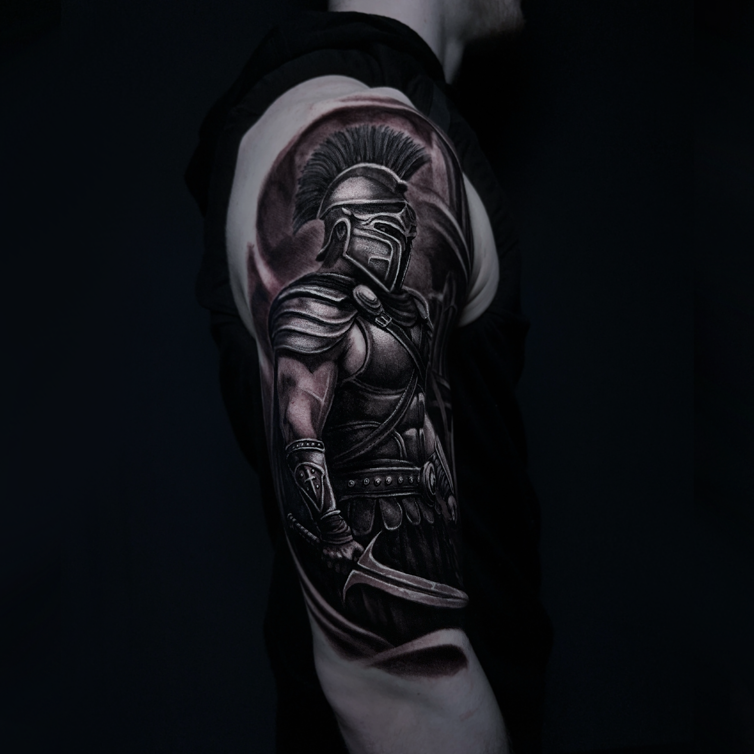 Dark realism tattoo of a gladiator done on an upper arm 