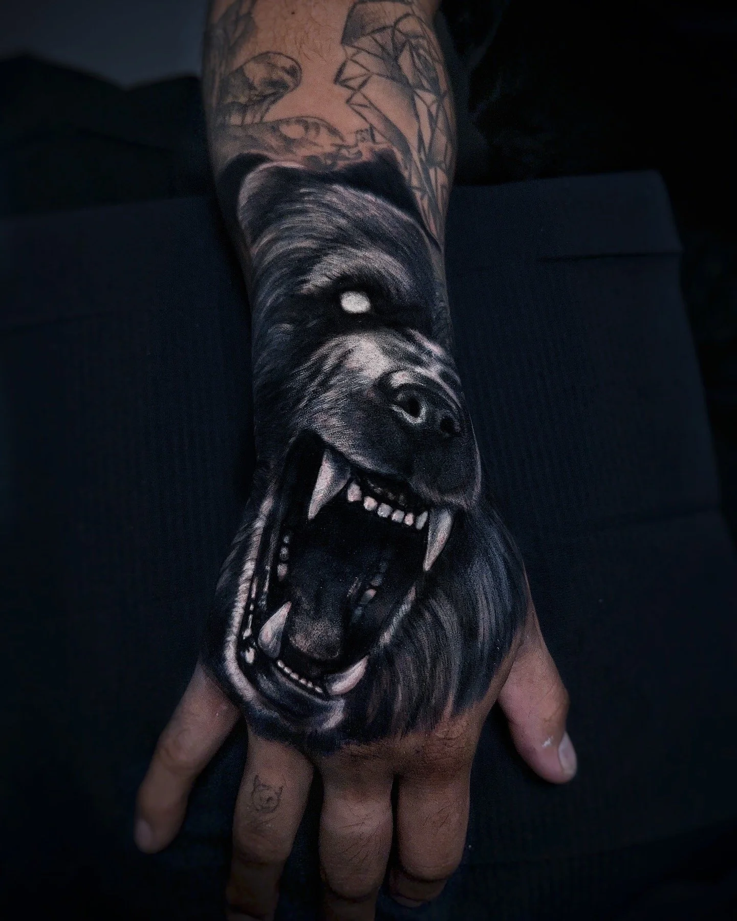Dark realism tattoo of a bear done on a hand 