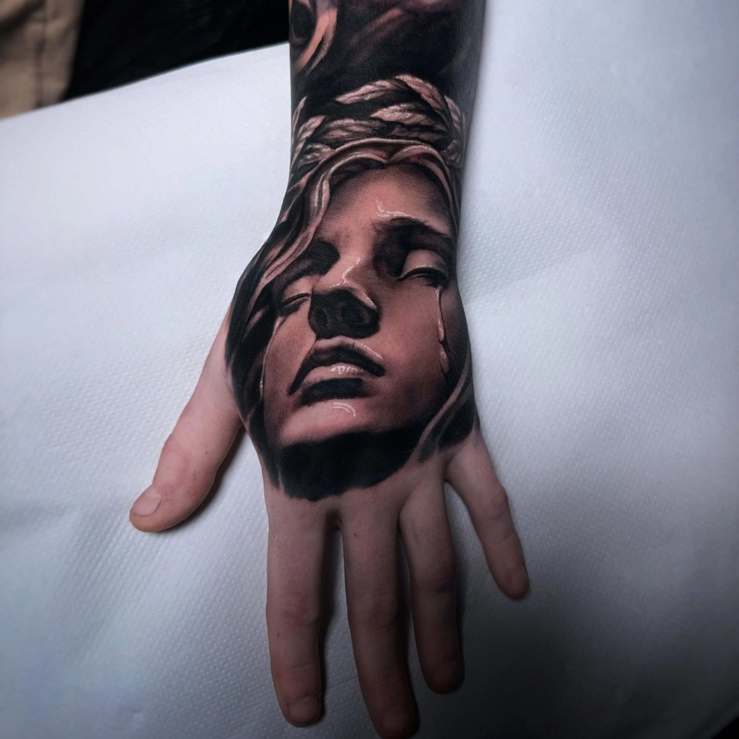 Realistic portrait tattoo done on a hand 