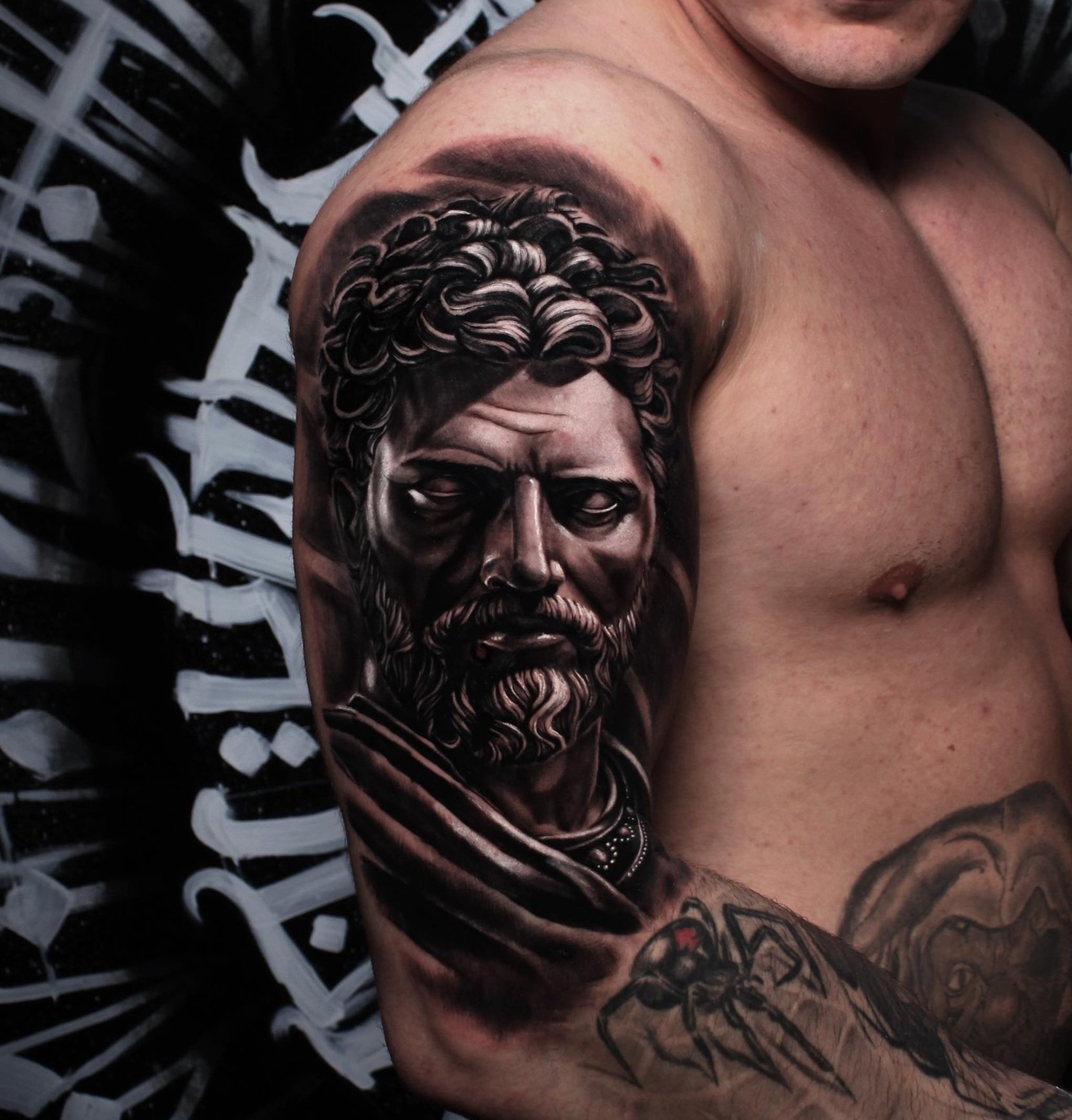 Realistic portrait tattoo of Marcus Aurelius on a upper arm