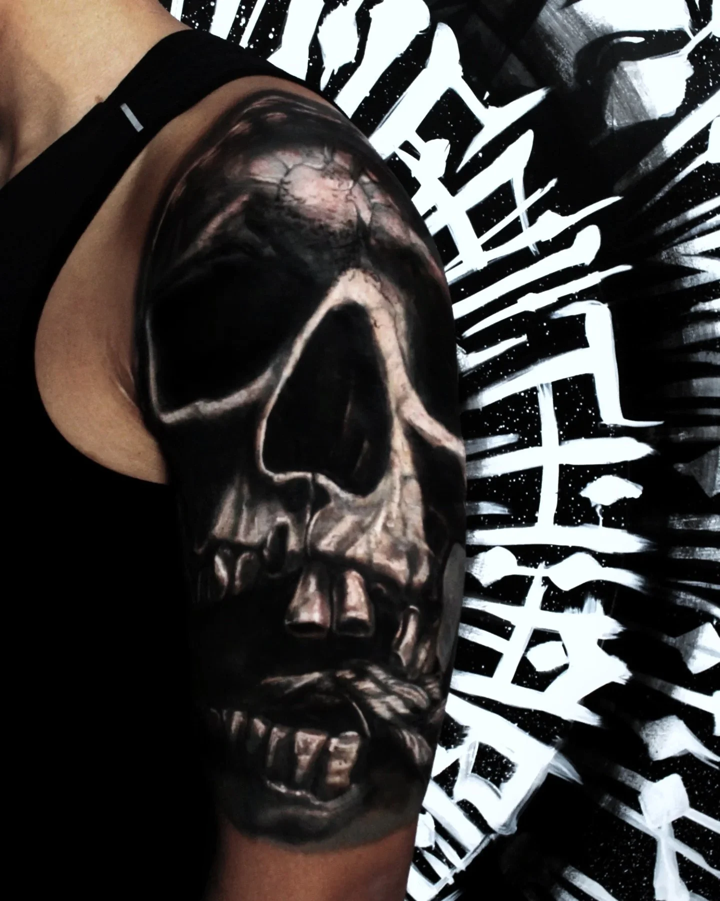 Dark realistic skull tattoo on an upper arm 