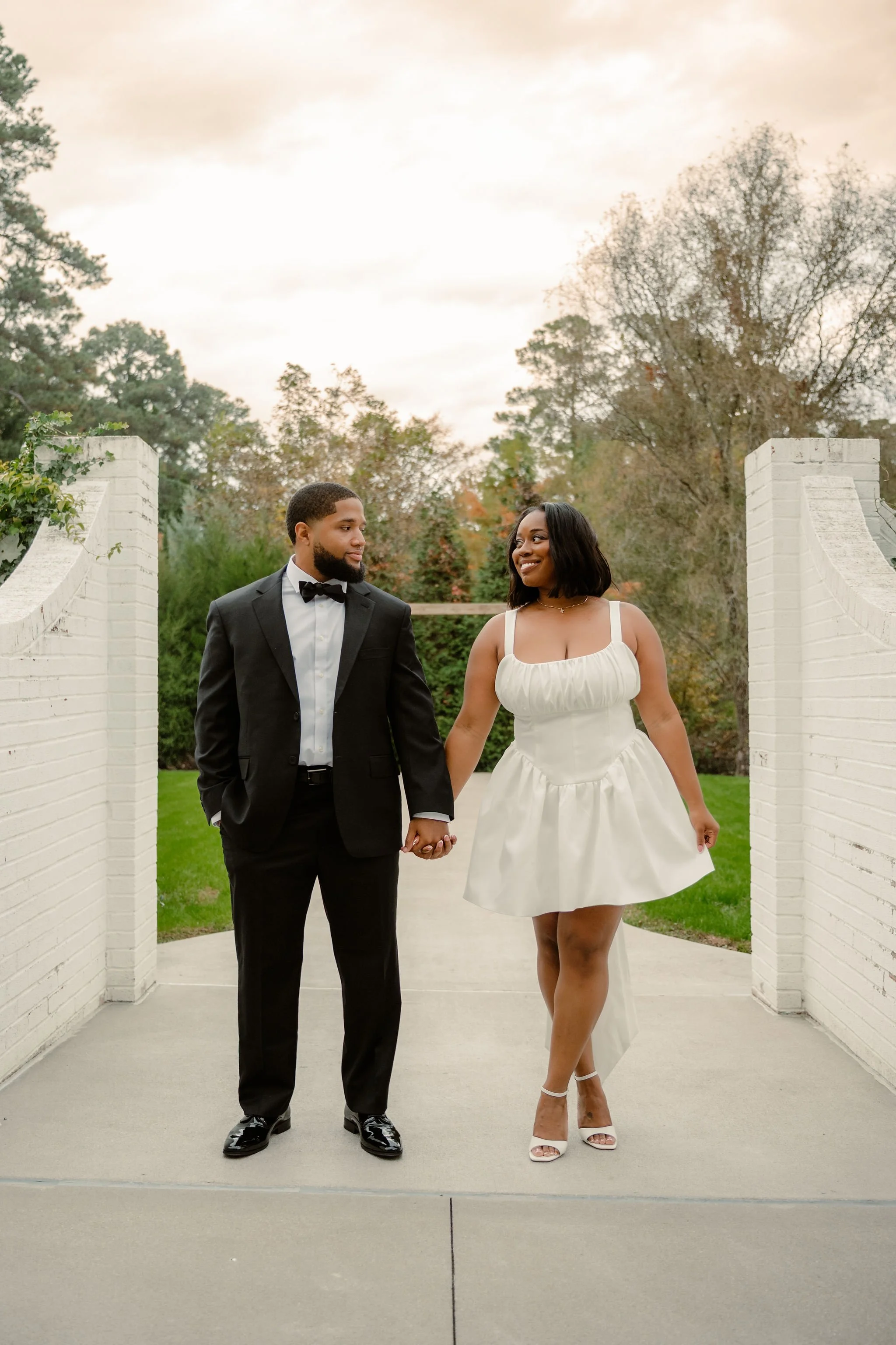 Flock of Canada geese swimming on a pond with a water fountain and trees in the background.