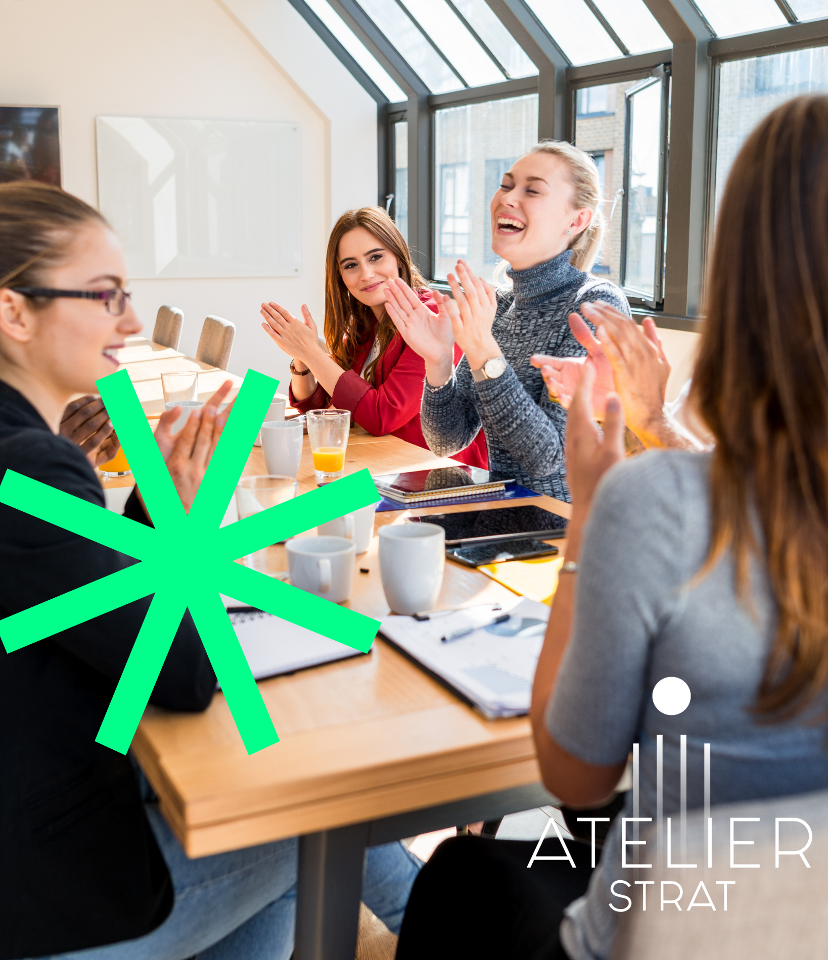 Groupe de femmes souriantes lors d'un atelier de discussion dans une salle lumineuse avec fenêtres en verre. Elles sont assises autour d'une table en bois avec des tasses, des carnets et un téléphone portable devant elles.