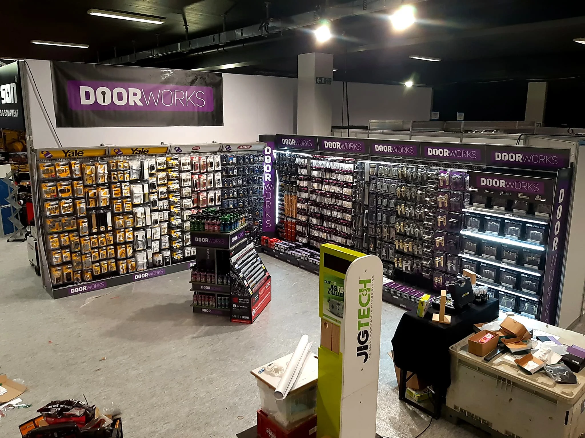 Interior of a store with shelves stocked with door hardware and accessories, with a large purple sign reading 'DOORWORKS'.