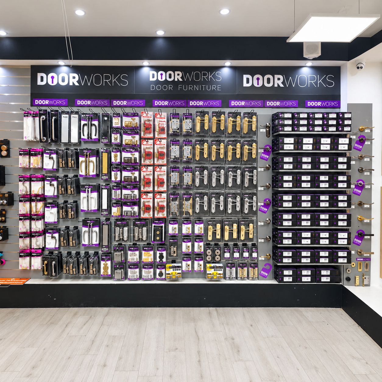 Display of various door hardware, including handles, locks, and hinges, organized on a retail wall in a hardware store.