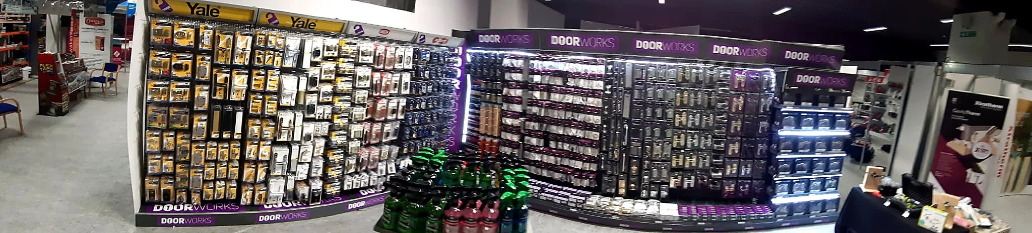 Shelf display of various door hardware items, including handles and locks, in a retail store.