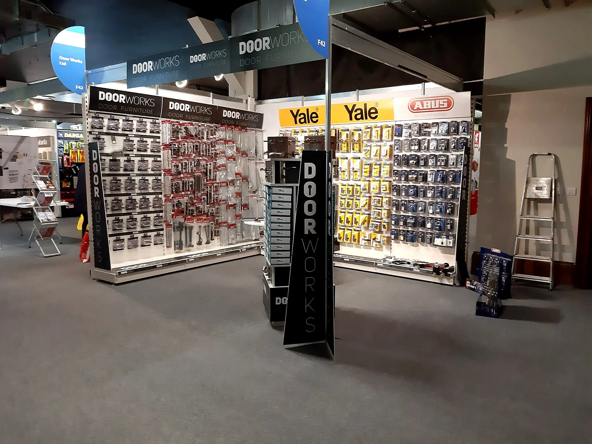 Display of door locks, door handles, and security accessories at a hardware store aisle.