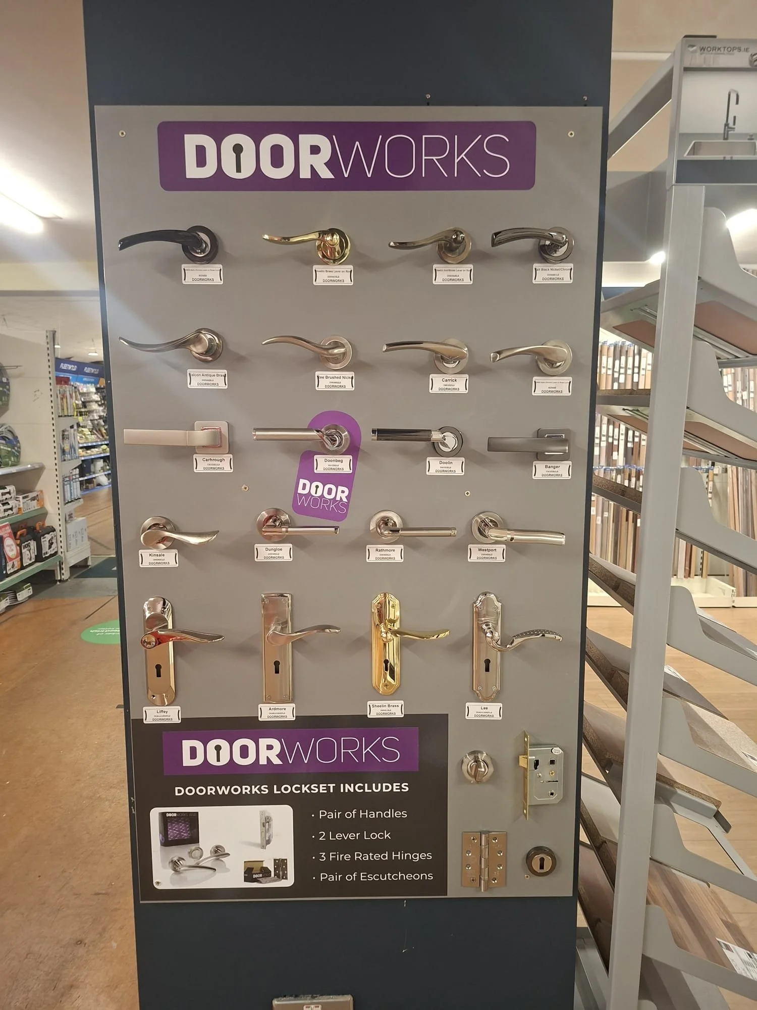 Display of various door handles and locks at a hardware store, with the 'DOORWORKS' brand prominent at the top.