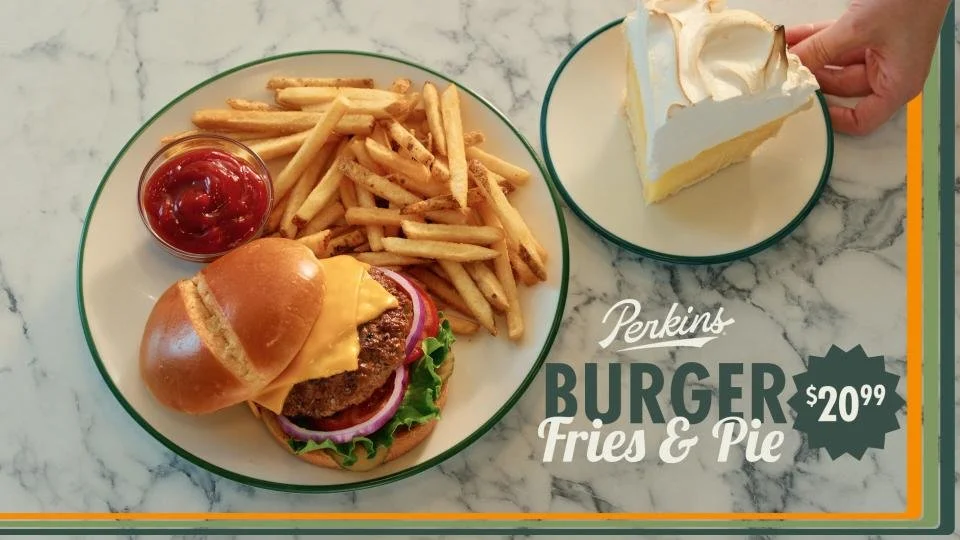 Plate with cheeseburger, French fries, ketchup, and a slice of whipped cream pie with a crust.