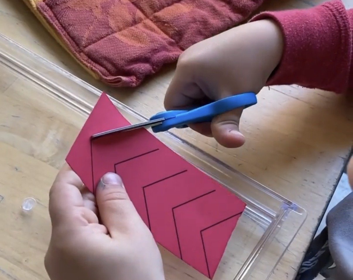 Montessori preschooler homeschooling while building cutting skills with scissors