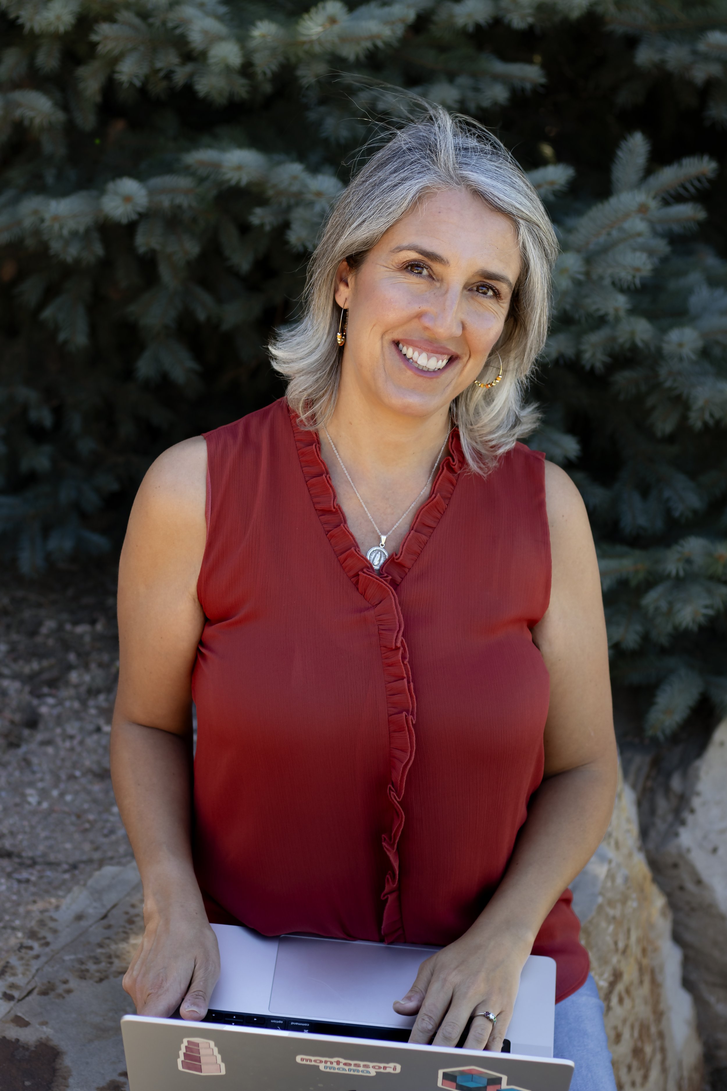 Founder and AMI Montessori Guide and homeschooling mom, Pilar, smiles for a photo outdoors