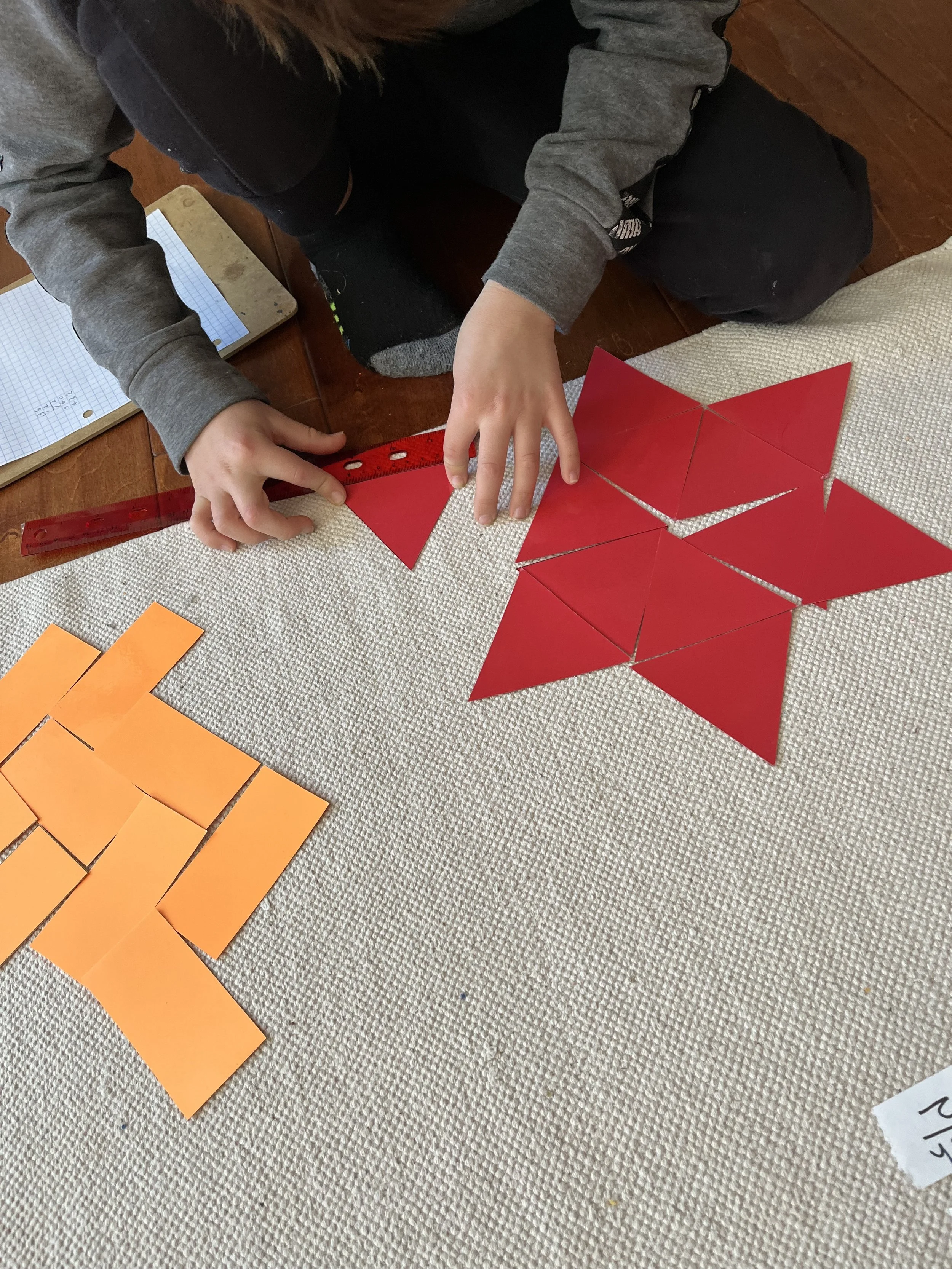Children use a ruler to complete a Montessori Elementary Homeschool lesson in geometry work
