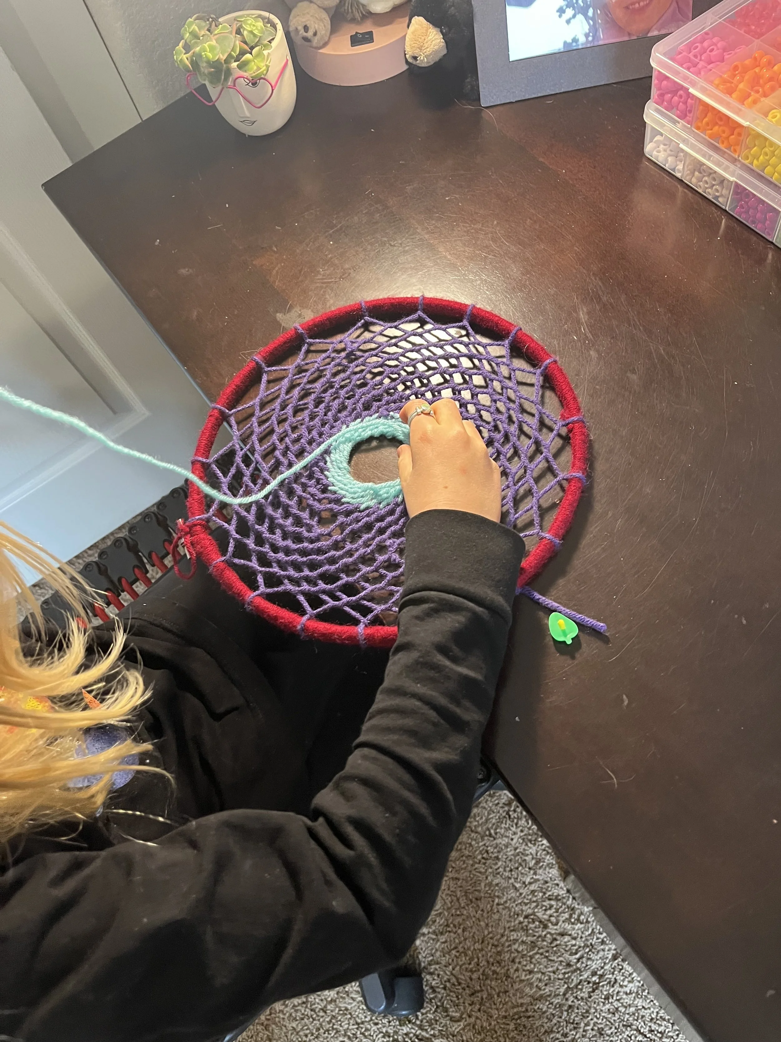 A Montessori homeschool child works on handwork at a table