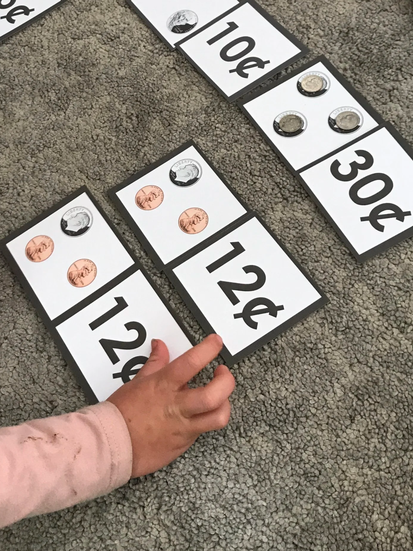 child completes a Montessori homeschool math lesson in money value