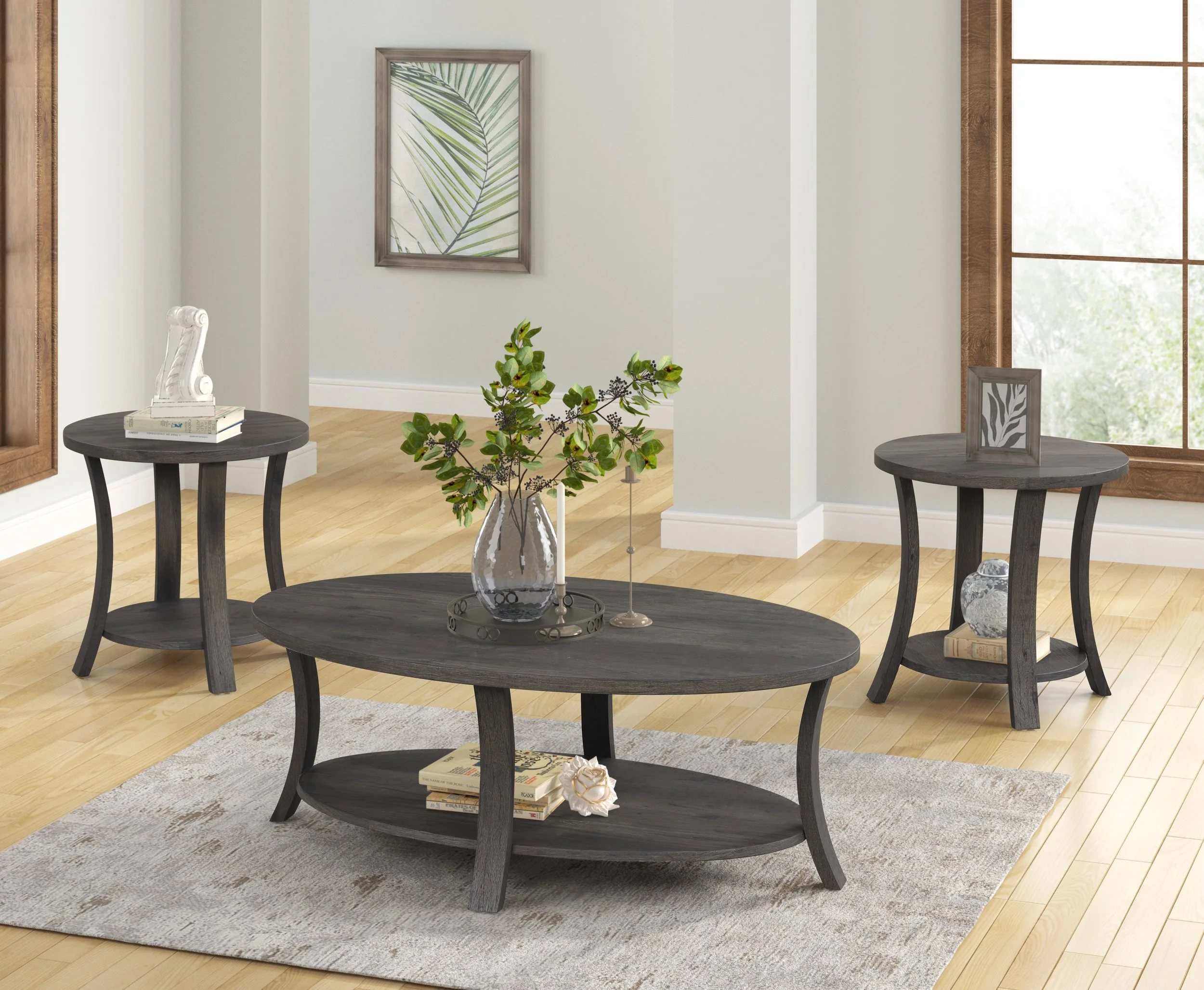 Living room with light-colored hardwood floors, white walls, large window, and dark gray coffee table and side tables decorated with books and plants.