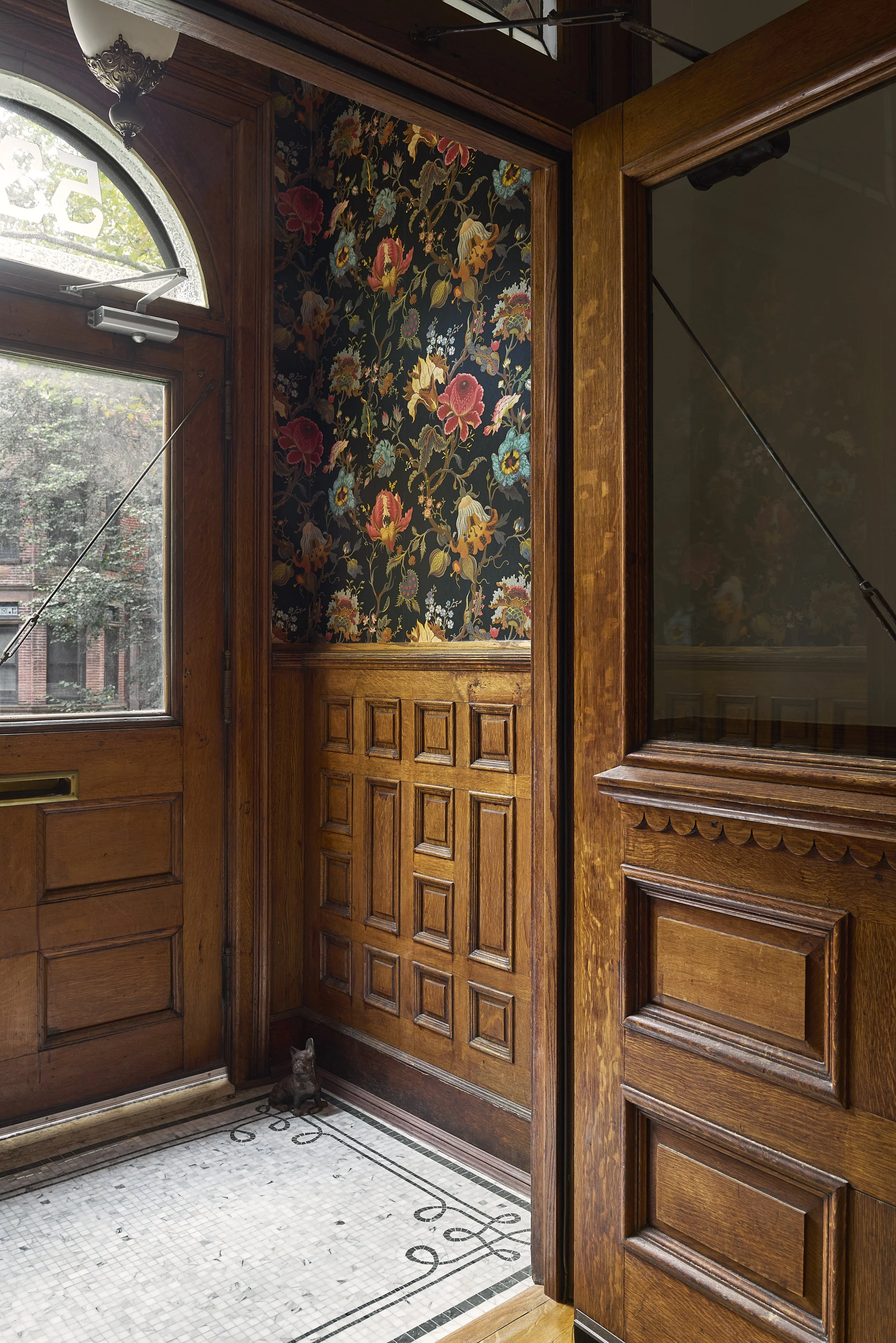 foyer with custom mosaic floors and wallpaper