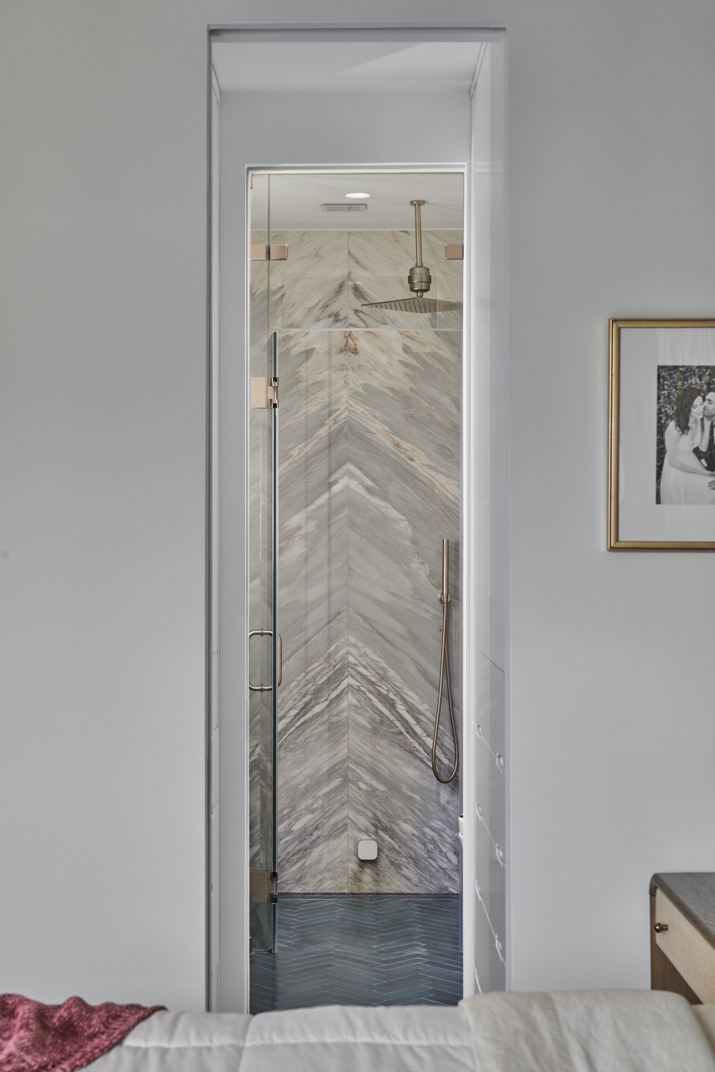 primary bath shower custom stone installation and herringbone floor tile