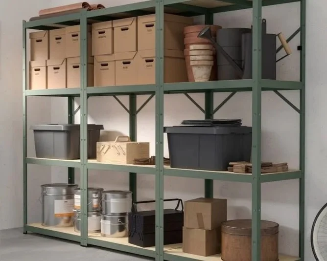 Green metal shelving unit filled with storage boxes, baskets, and containers in a garage or storage room.