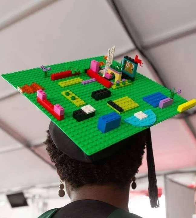 Caroline Bryan, LPC, MT-BC, is wearing a black graduation cap with LEGOs on top of the cap..