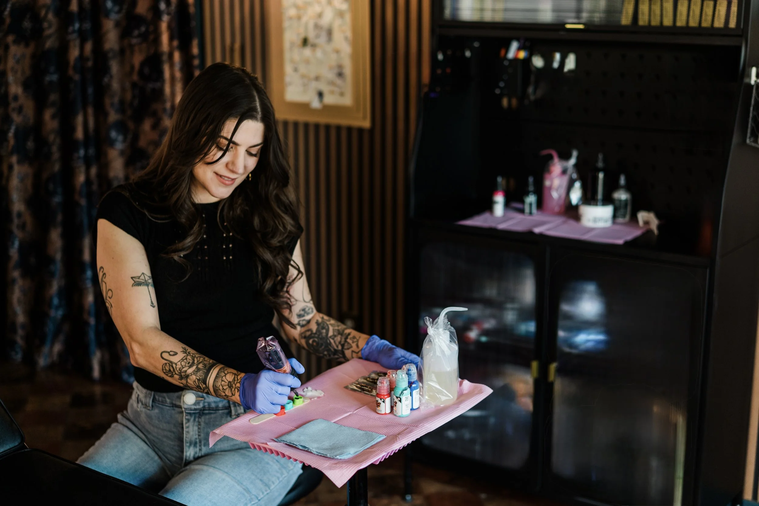 female tattoo artist in sacramento sitting at her tattoo station ready to start on a tattoo