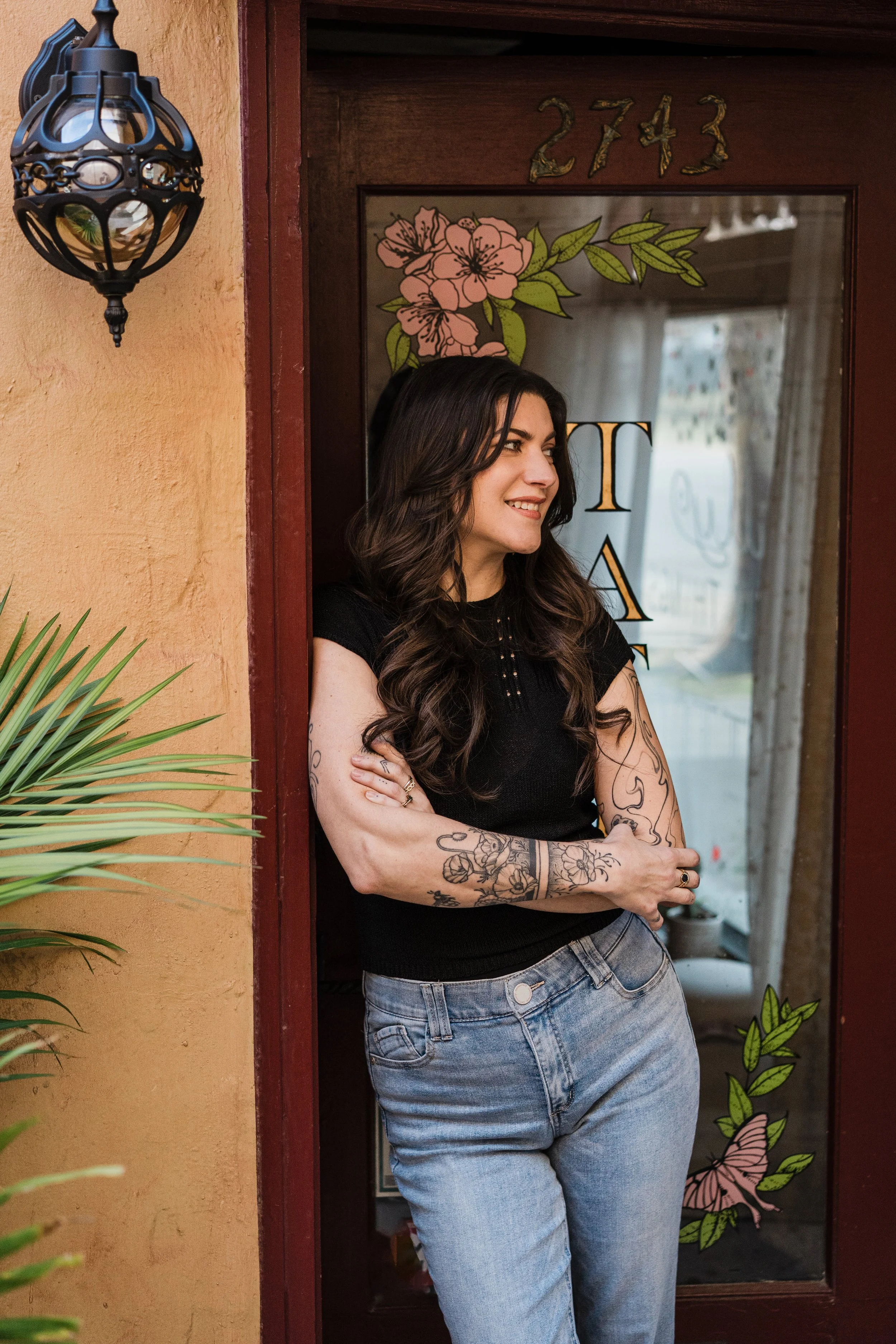 female tattoo artist standing at the entrance to the tattoo shop