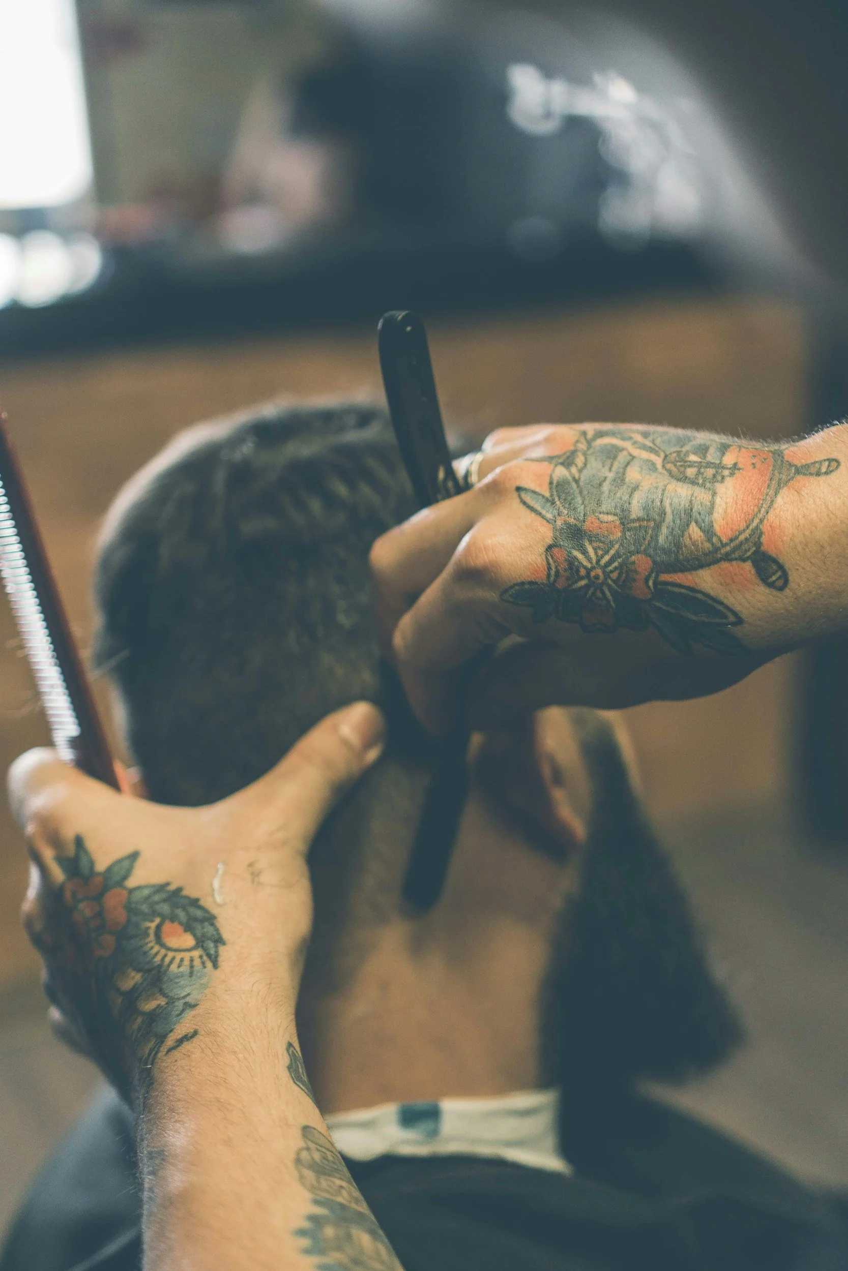 Barber performing fade haircut using clippers at Rebel Hearts Barbering in Brookside, Kansas City