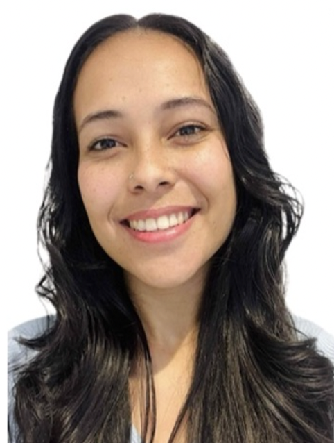 A young woman with long, wavy black hair, light skin, and a nose piercing smiling at the camera.