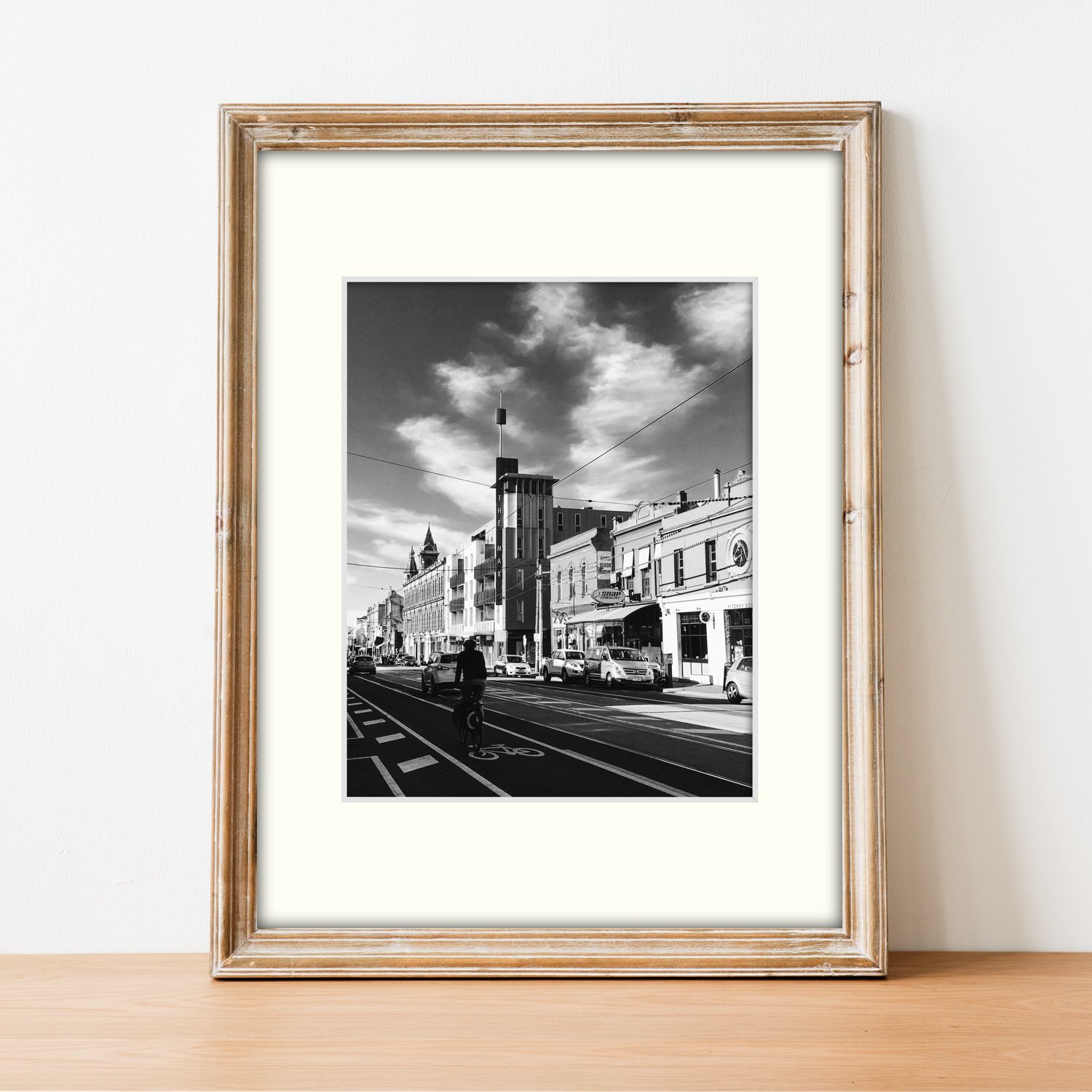 The Brunswick Street Rhythm print and mount is presented in a slim wooden frame on a sideboard.