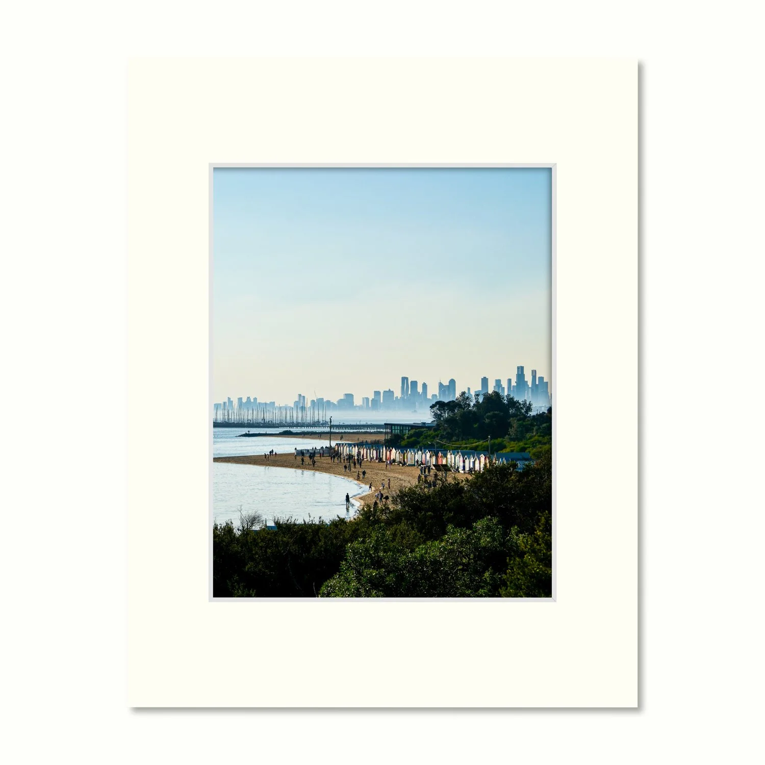 Photography print of the Melbourne skyline and bayside beach boxes in an off-white mount, displayed on a cream background.