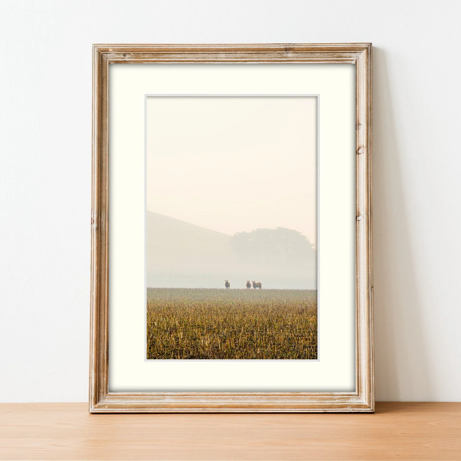 Frame mount with the Through the Haze print, vertical perspective in finalised picture frame sitting on sideboard.