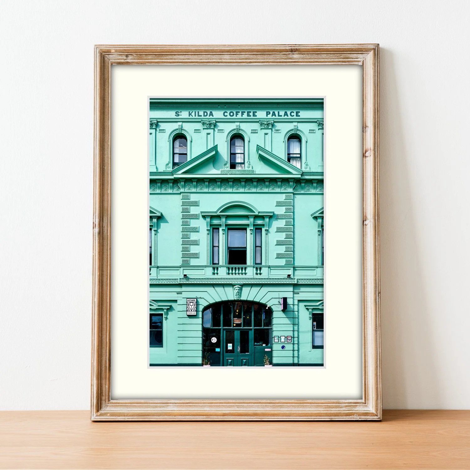Frame mount with print of Coffee Palace in finalised picture frame sitting on sideboard.