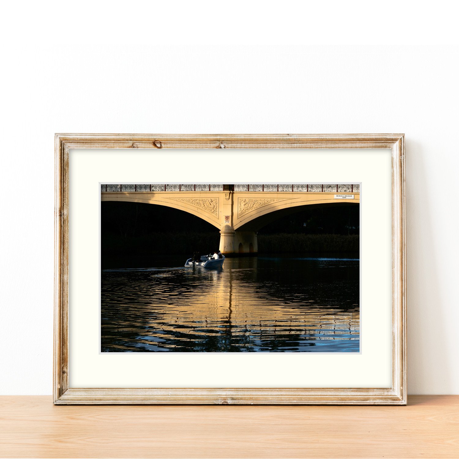 The Under the Arch print is framed in a slim wooden frame, sitting on a sideboard.