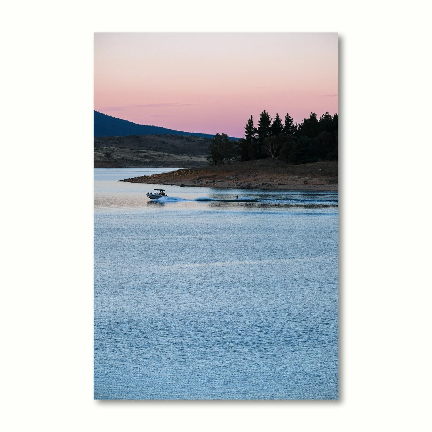 Vertical print of a lake and mountains at twilight with a sky of pink and mauve hues.