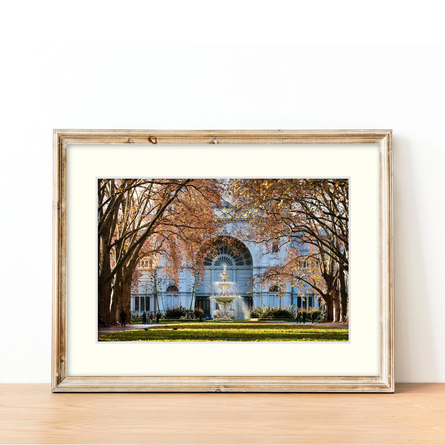 The Exhibition Gardens print and mat board framed in modern oak and sitting on a sideboard.