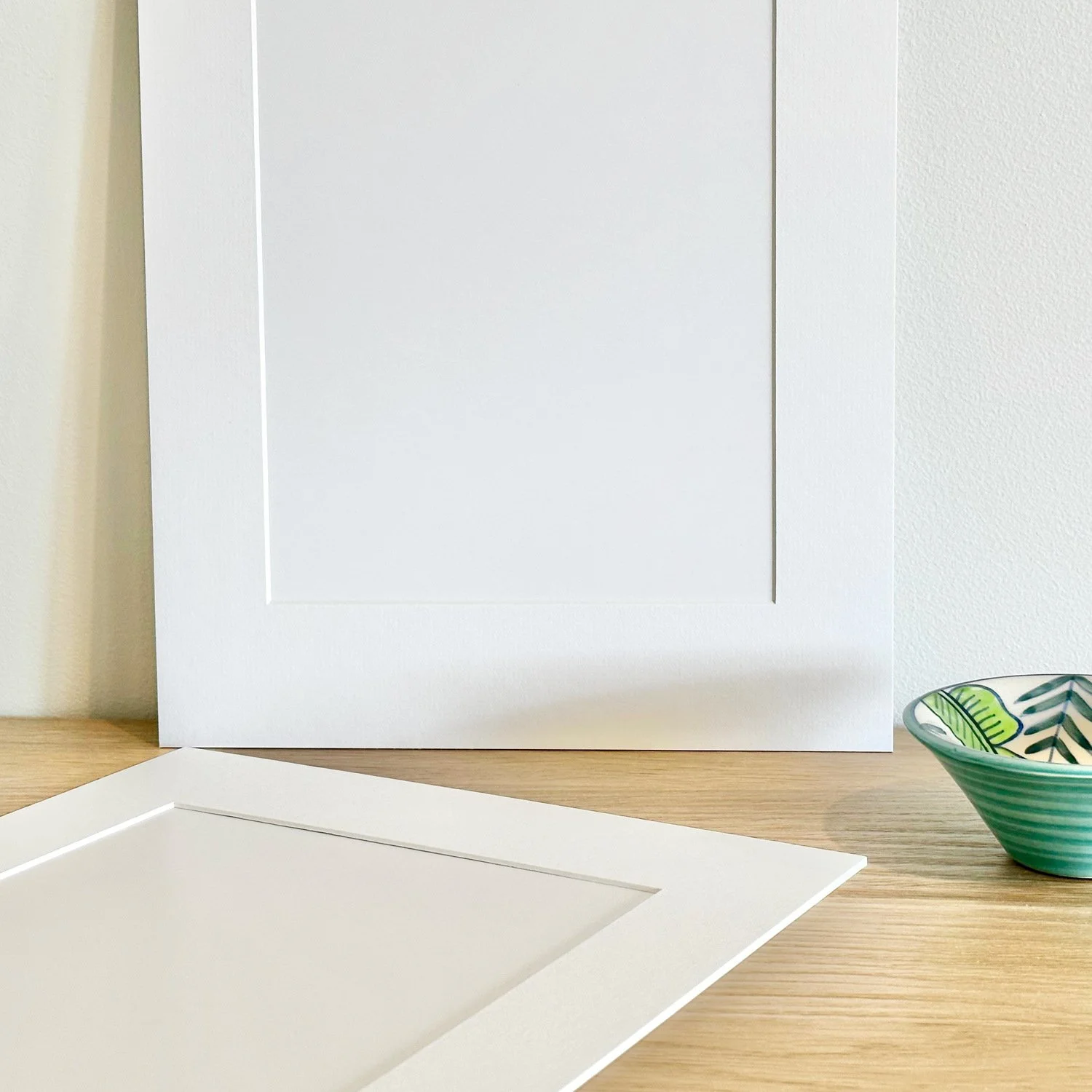 Two frame mounts on sideboard before the Bayside Horizon print is inserted.