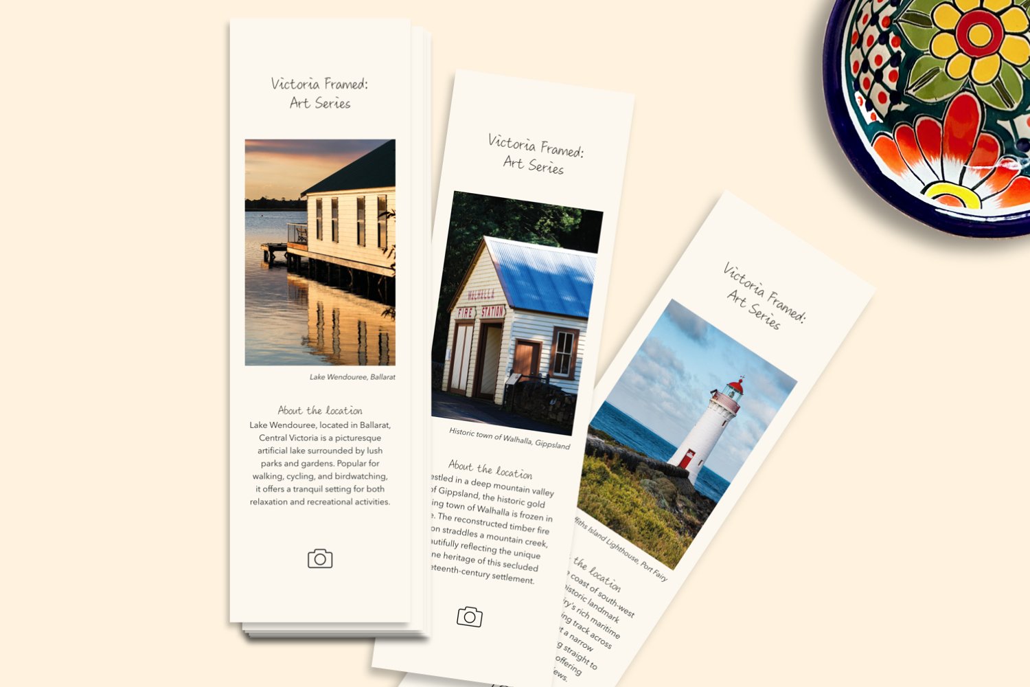 A flat lay display of bookmarks with vivid photos and a small decorative bowl to lend scale to the scene.