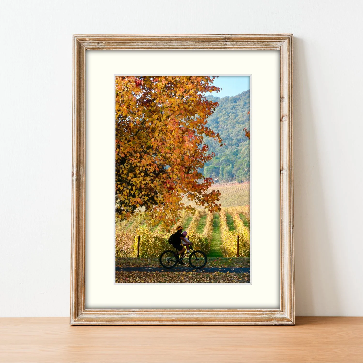 Frame mount with print of Riding by the Vineyard in finalised picture frame sitting on sideboard.