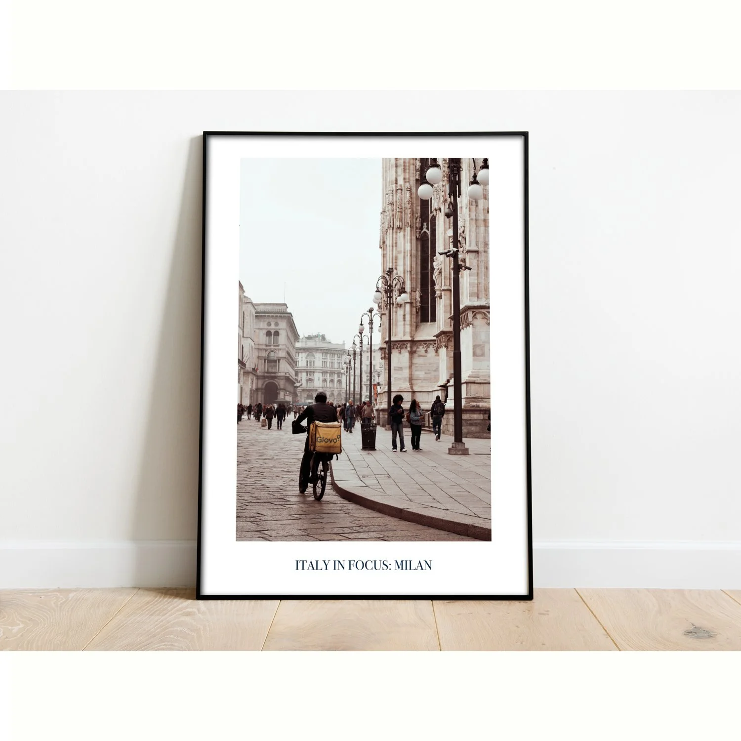 The poster entitled Italy in Focus: Milan is framed and sitting on the floor.
